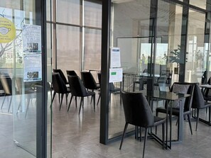 A modern meeting room with glass walls, black chairs, and a glass table. - The Rich Rama 9 - Srinakarin (Khet Suan Luang)