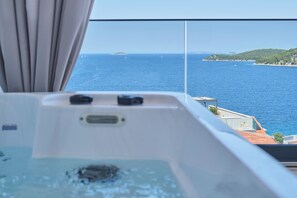 A hot tub with a view of the sea and a distant island. - Apartment Maestral (Ražanj)