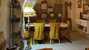 A cozy living room with a dining area, a lamp, and a sofa.