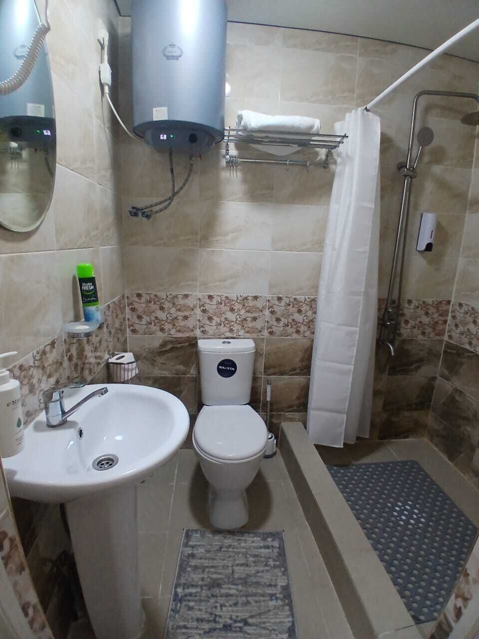 Un baño con lavamanos, inodoro y zona de ducha.