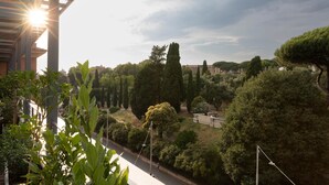 Vista di un parco con alberi, un sentiero e un edificio con una pergola.