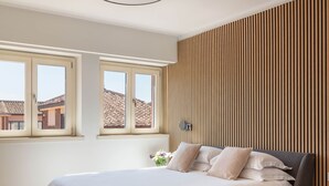Una camera da letto moderna con un letto grande, una parete rivestita in legno e una lampada a soffitto.