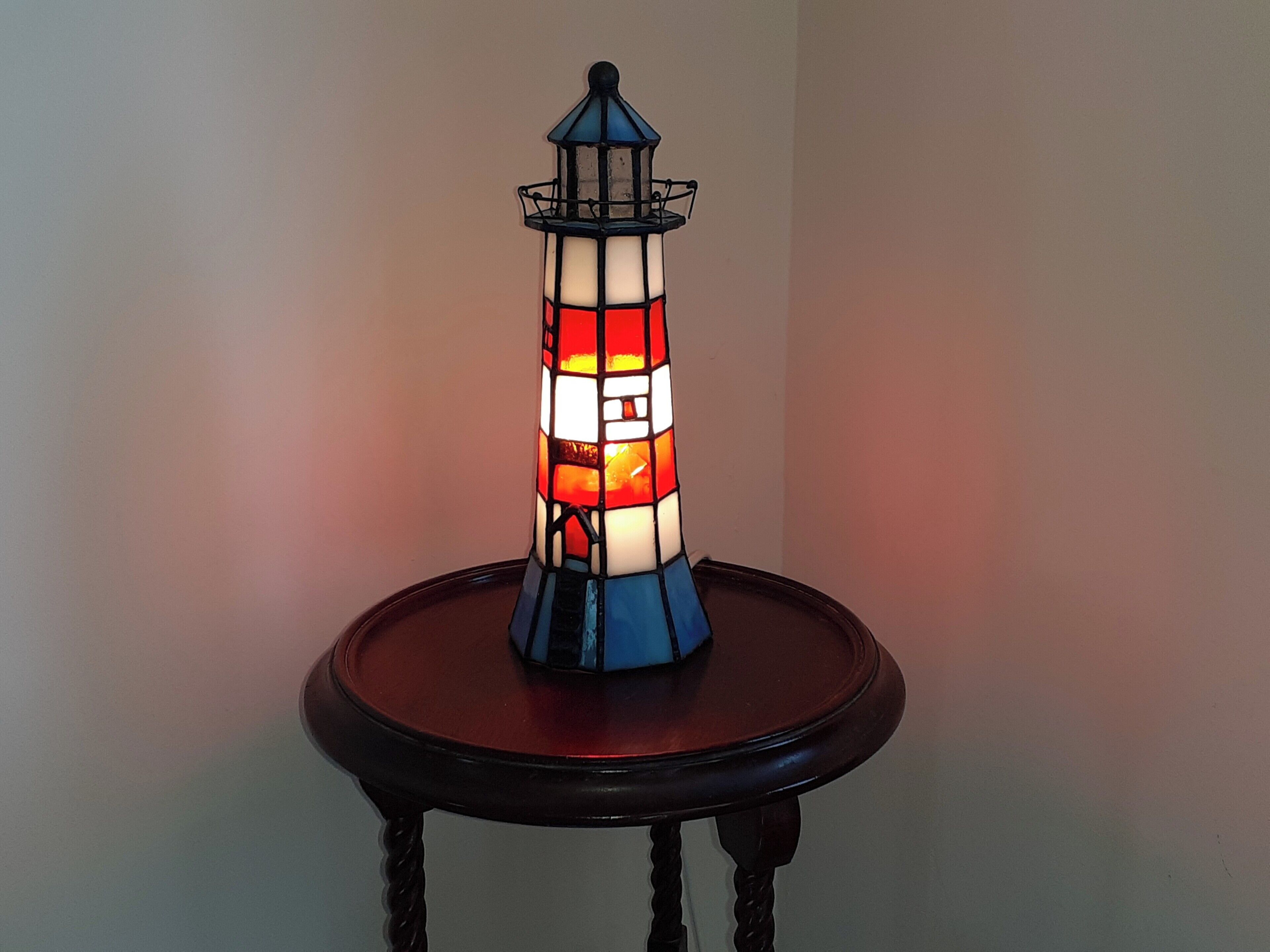 Eine Tischlampe im Leuchtturm-Design mit Holzfuß.