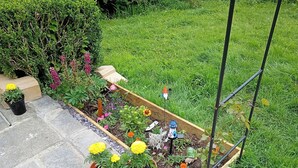 Un jardí amb alçades, plantes en testos i ornaments de jardí.