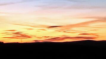 Un coucher de soleil avec la silhouette d’un paysage.