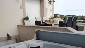 A hot tub with a view of the countryside, outdoor seating, and a lamp post.