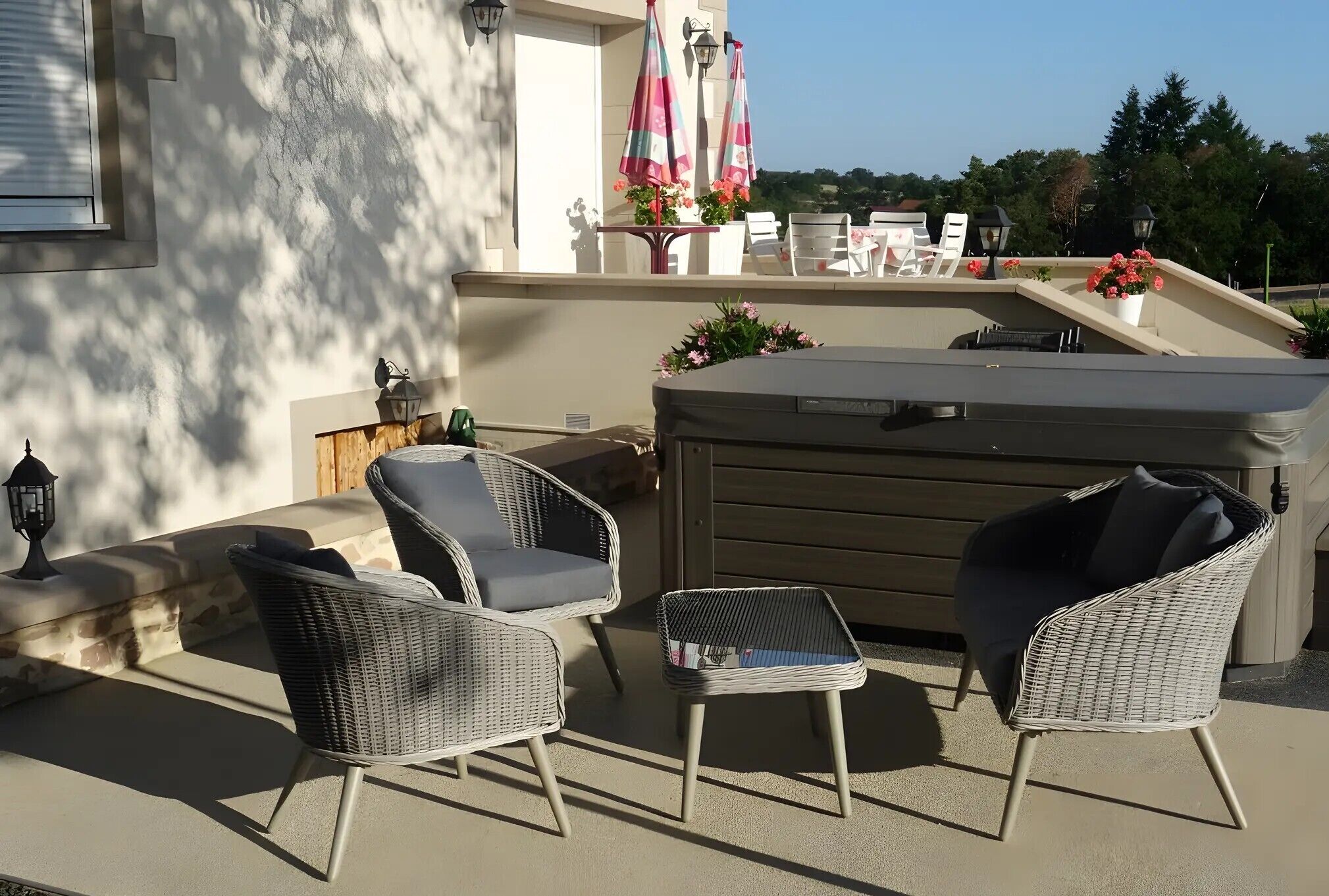 An outdoor patio with wicker furniture, a small table, and a barbecue grill.