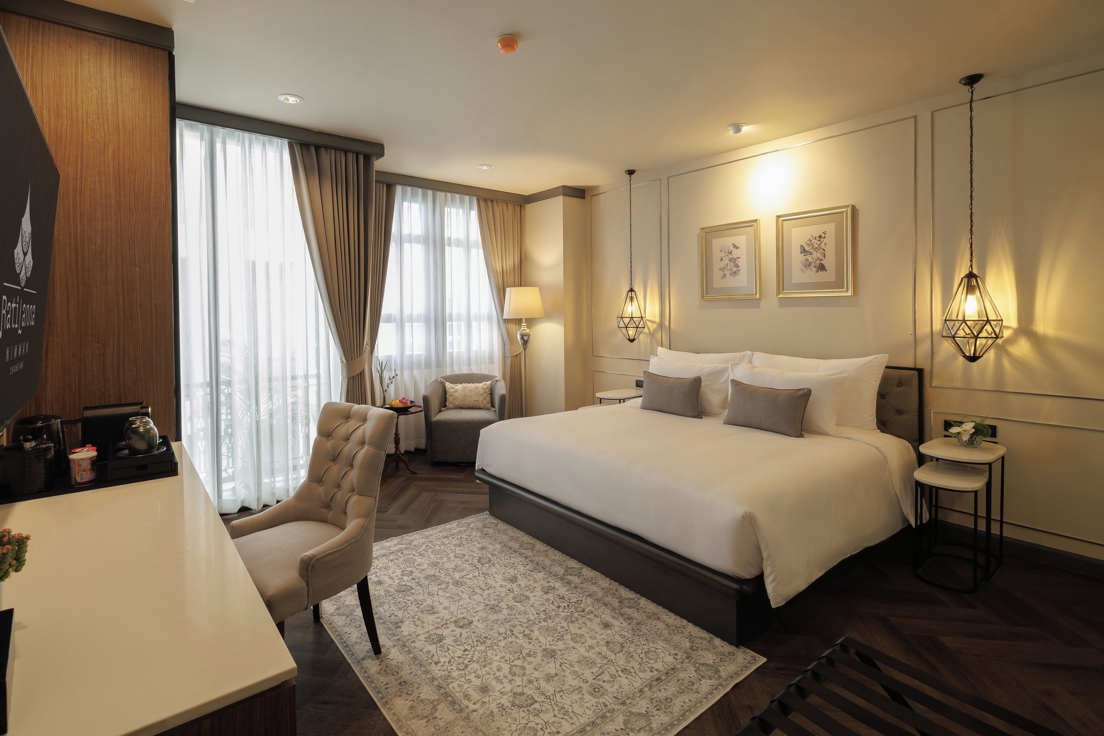 Una habitación de hotel con una cama, un escritorio, una silla, una mesita y una lámpara.