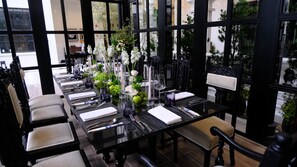 Un comedor con una larga mesa dispuesta para una comida, rodeada de sillas.