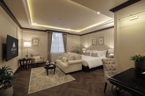 A hotel room with a bed, a sofa, a coffee table, and a TV. - RatiLanna Nimman (Chiang Mai)