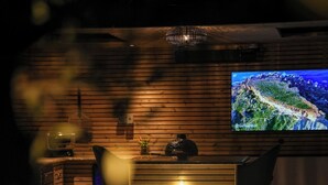 A reception area with a wooden wall, a television screen, and a glowing light feature. - Serenity Villa (Beccles)