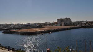 Una zona ribereña con un edificio grande, un muelle y cielo despejado.