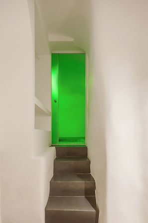 Eine Treppe führt zu einem Zimmer mit einer grünen Tür.