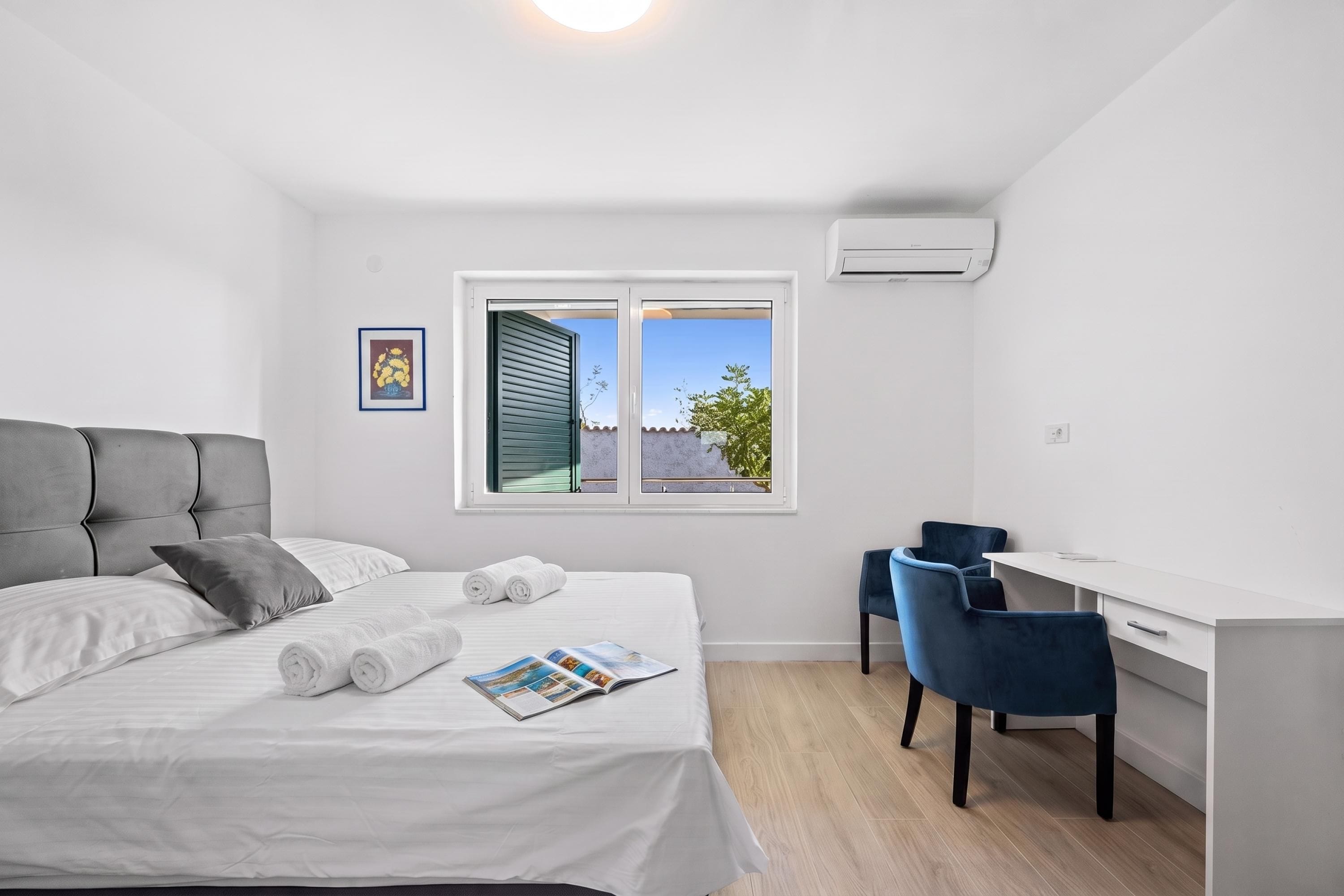 A modern bedroom with a bed, a desk, and a chair.