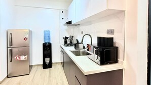 Ett modernt kök med vitvaror i rostfritt stål, en vattenautomat och en integrerad diskho.