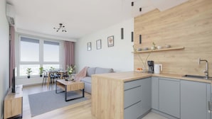 A modern kitchen with grey cabinets, a wooden countertop, and a built-in sink.