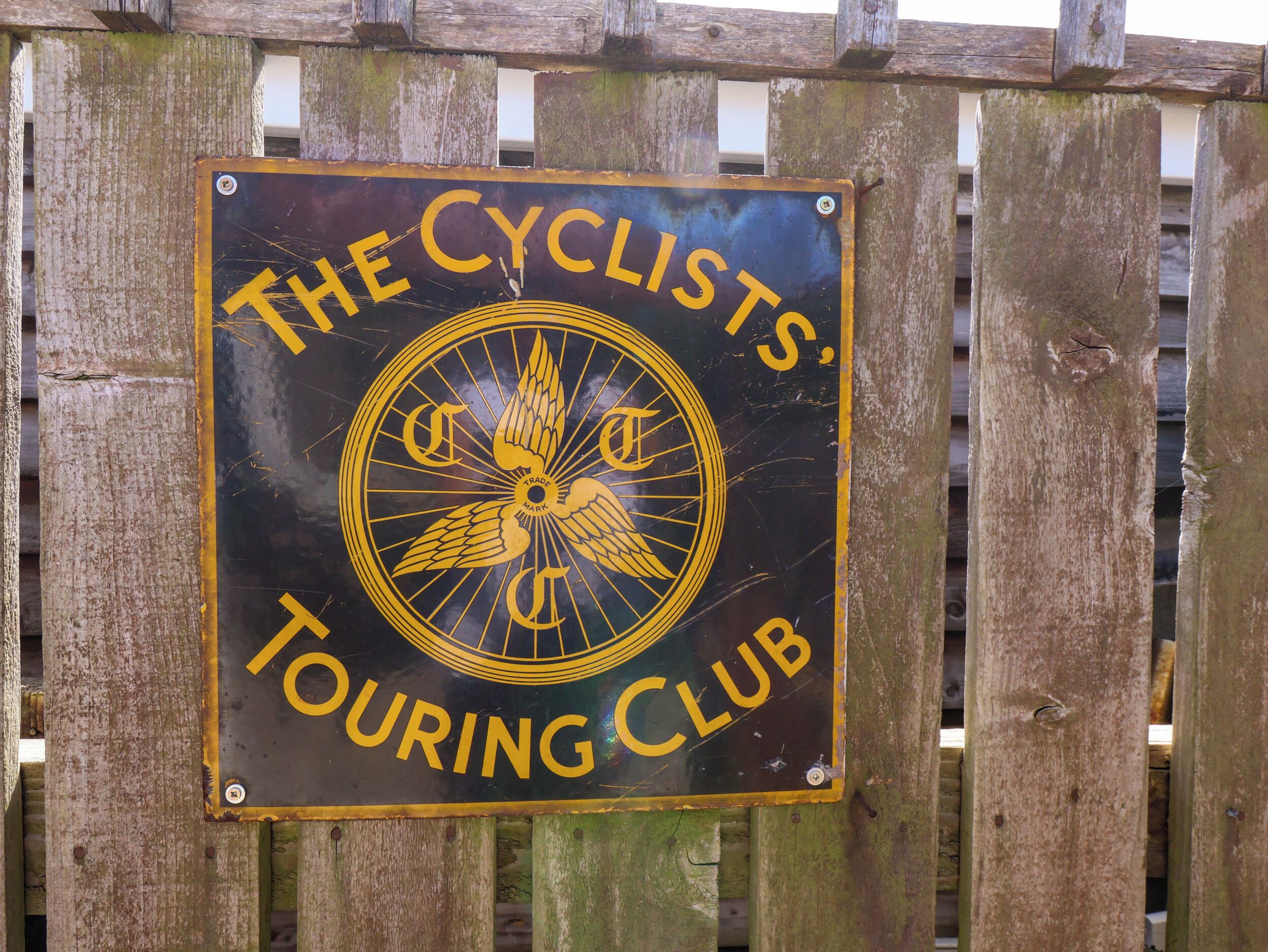 A sign for 'The Cyclists Touring Club' with a logo featuring a winged wheel.