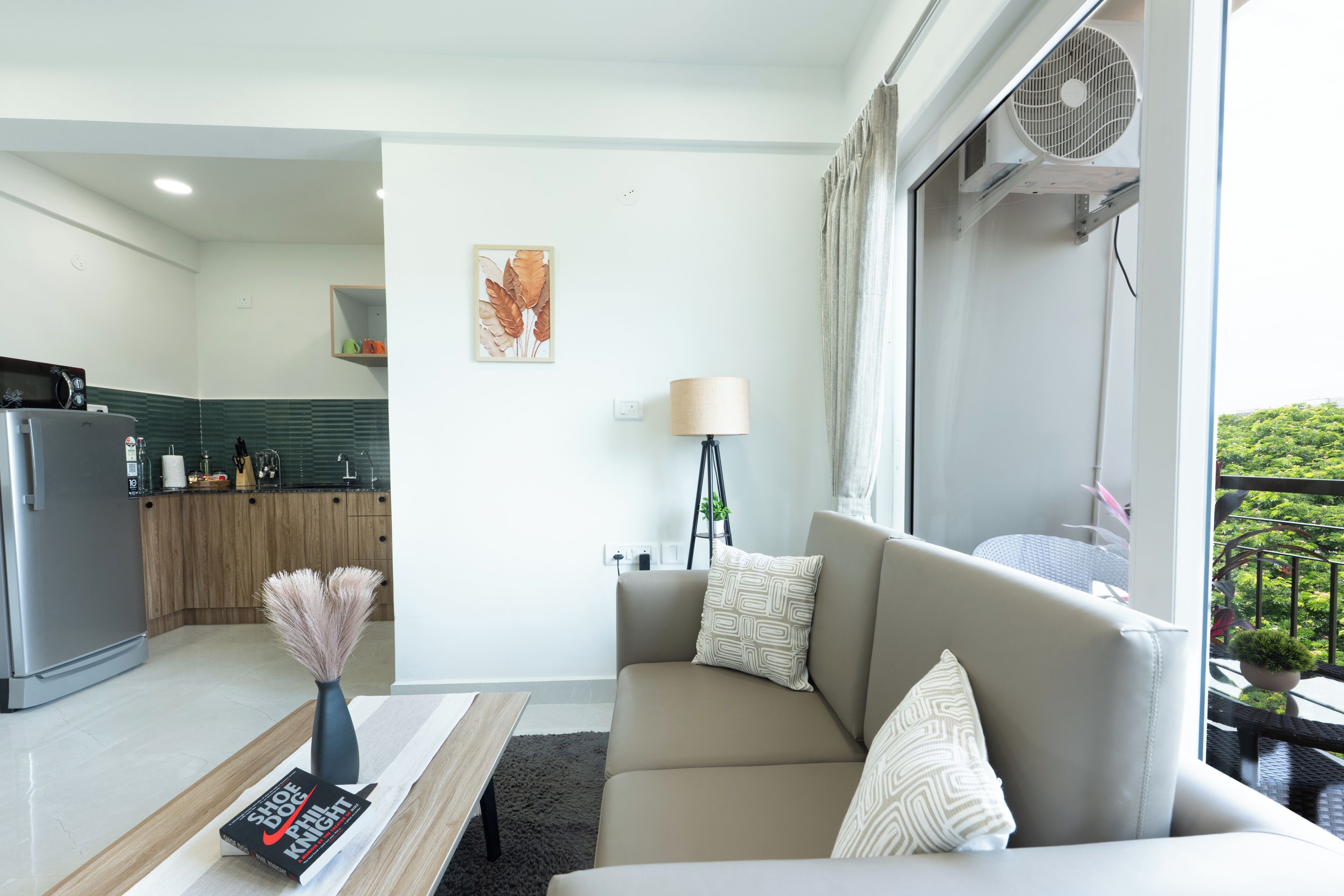A modern living room with a sofa, a coffee table, a lamp, and a bookshelf.