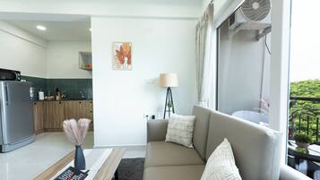A modern living room with a sofa, a coffee table, a lamp, and a bookshelf.