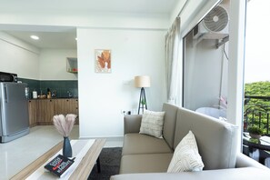 Een moderne woonkamer met een bank, een salontafel, een lamp en een boekenkast.