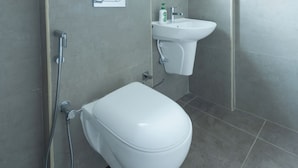 Et moderne badeværelse med toilet, håndvask og brusebad.