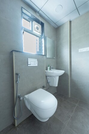 Een moderne badkamer met toilet, wastafel en douche.