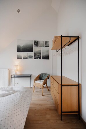 Ein Schlafzimmer mit einem Etagenbett, einem Schreibtisch, einem Stuhl und einer Wand mit gerahmten Bildern.