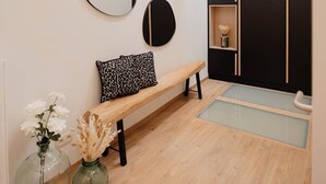Ein modernes Interieur mit einer Bank, Spiegeln und einem schwarzen Kleiderschrank.