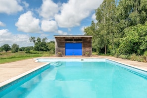 Ein Schwimmbecken mit Holzkonstruktion und blauer Tür.