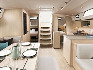 A compact, well-lit interior with a dining area, kitchenette, and seating arrangements.