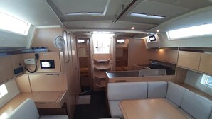 A compact interior with seating, a small kitchenette, and a control panel. - Sun-Kissed Sailing Adventure in Phuket (Mai Khao)