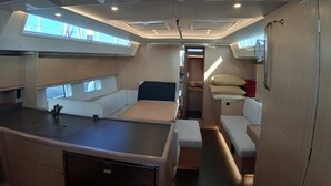 A compact interior with a bed, seating area, and a small kitchenette. - Sun-Kissed Sailing Adventure in Phuket (Mai Khao)