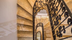 A spiral staircase with ornate metal railings and a mirrored wall. - 7 Main Gate - Double Room with Balcony (Birgu)