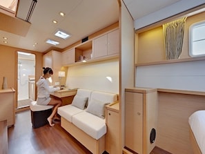 A compact, well-lit interior with a sofa, a small table, and a cabinet.