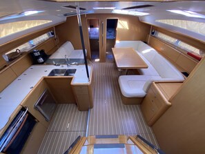 A compact galley with a sink, stove, and storage cabinets. - Sun-Kissed Sailing Adventure in Islas Sarónicas (Alimos)
