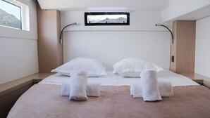 Ein modernes Hotelzimmer mit einem Bett, zwei Kissen, einem Fenster und Bergblick.
