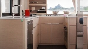 Eine kleine Küche mit Fenster, Spüle und Herd.