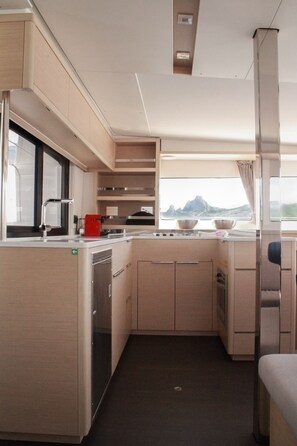 Una cocina compacta con ventana, un lavamanos y una estufa.