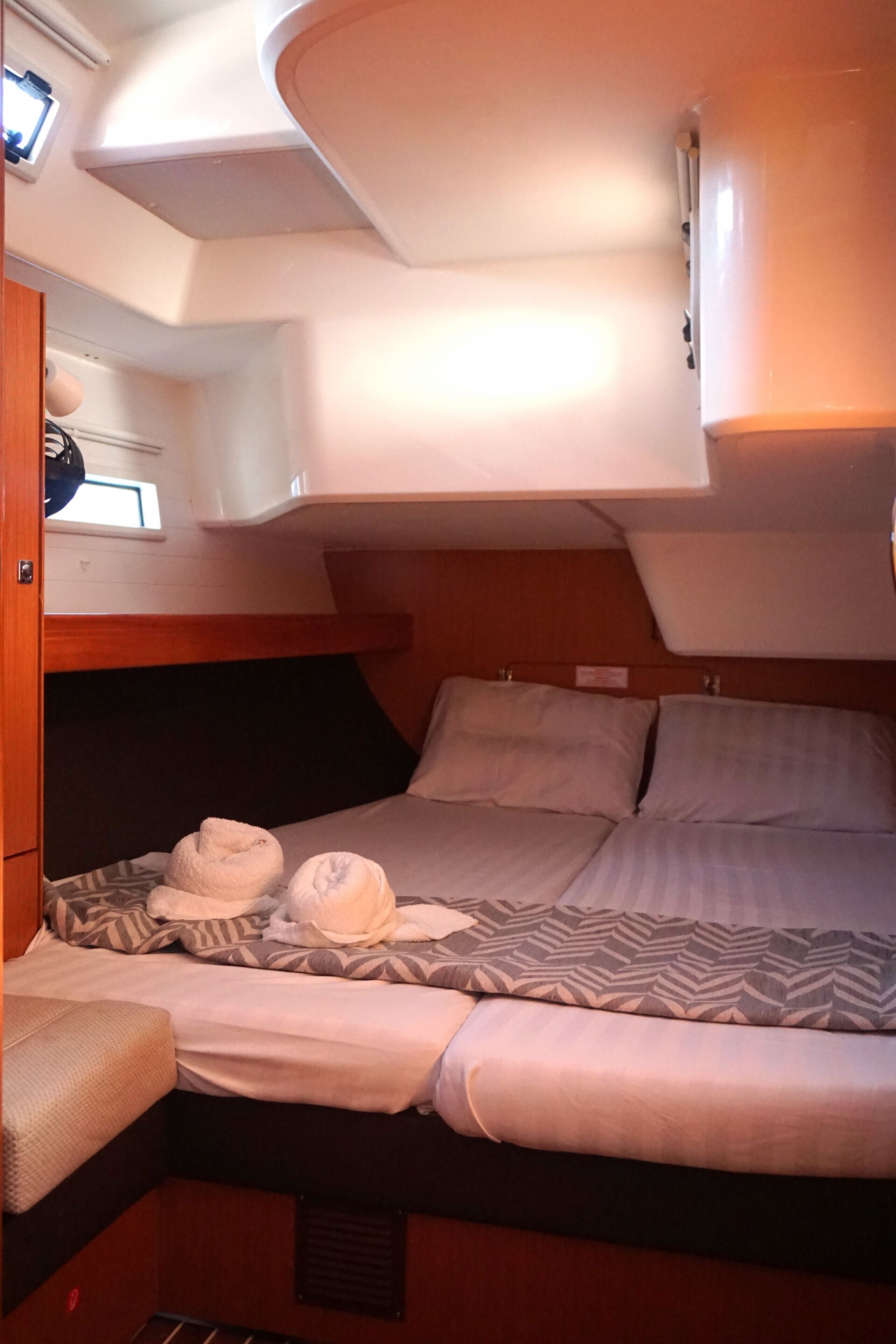A compact cabin with a bunk bed, a small seating area, and a window.