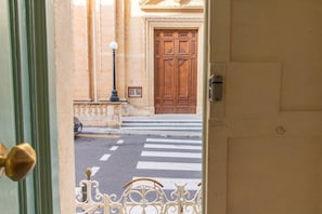 Une vue à travers une porte donnant sur une rue, avec une porte en bois et un lampadaire.