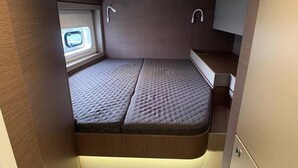 A compact RV interior with a bed, a skylight, and a small window. - Sun-Kissed Sailing Adventure in the Ionian Islands, Lefkada (Lefkada)