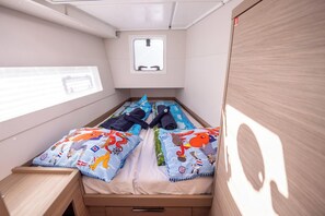 A small, compact bedroom with a single bed, a window, and a small table. - Sun-Kissed Sailing Adventure in Sibenik, Croatia (Primošten)