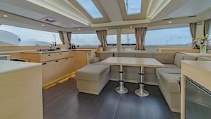 Een modern interieur met een keuken, zithoek en grote ramen.