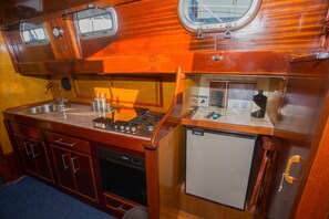 Eine kleine Küche mit Spüle, Herd und einem Kühlschrank.