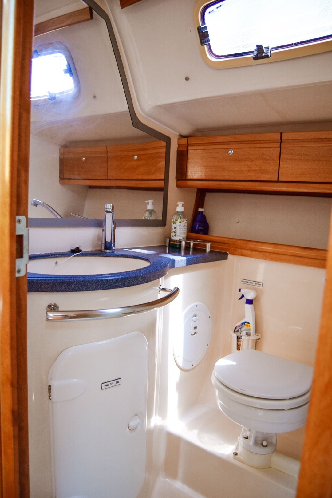 Une petite salle de bain comprenant des toilettes, un lavabo et un miroir.