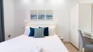 Escritorio, tabla de planchar con plancha, wifi y ropa de cama
