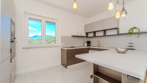 Eine moderne Küche mit einem großen Fenster, einer Spüle und einer Arbeitsfläche.