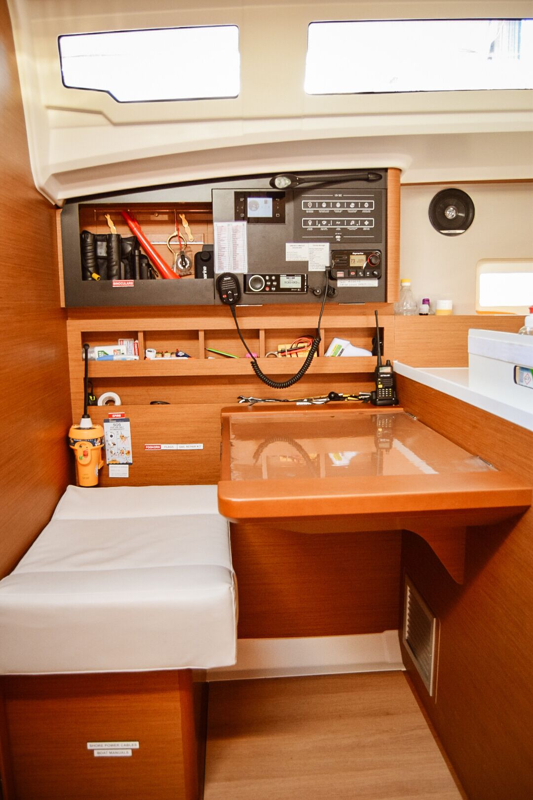 Un intérieur de bateau compact comprenant un panneau de commande, un petit évier et des compartiments de rangement.