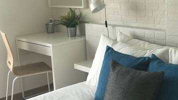 Escritorio, tabla de planchar con plancha, wifi y ropa de cama
