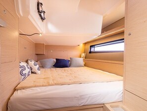 A compact, well-lit interior with a bed, storage cabinets, and a window providing natural light. - Sun-Kissed Sailing Adventure in Islas Baleares, Mallorca (Palma)